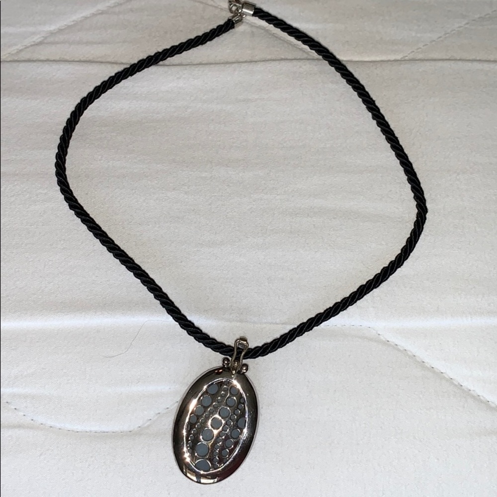 Silver pendant on black cord